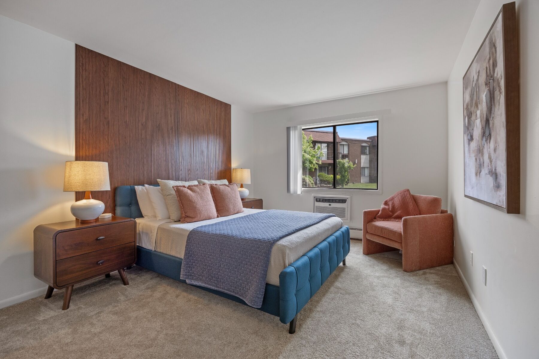 Queen bedroom with upholstered bed, chair, and large window