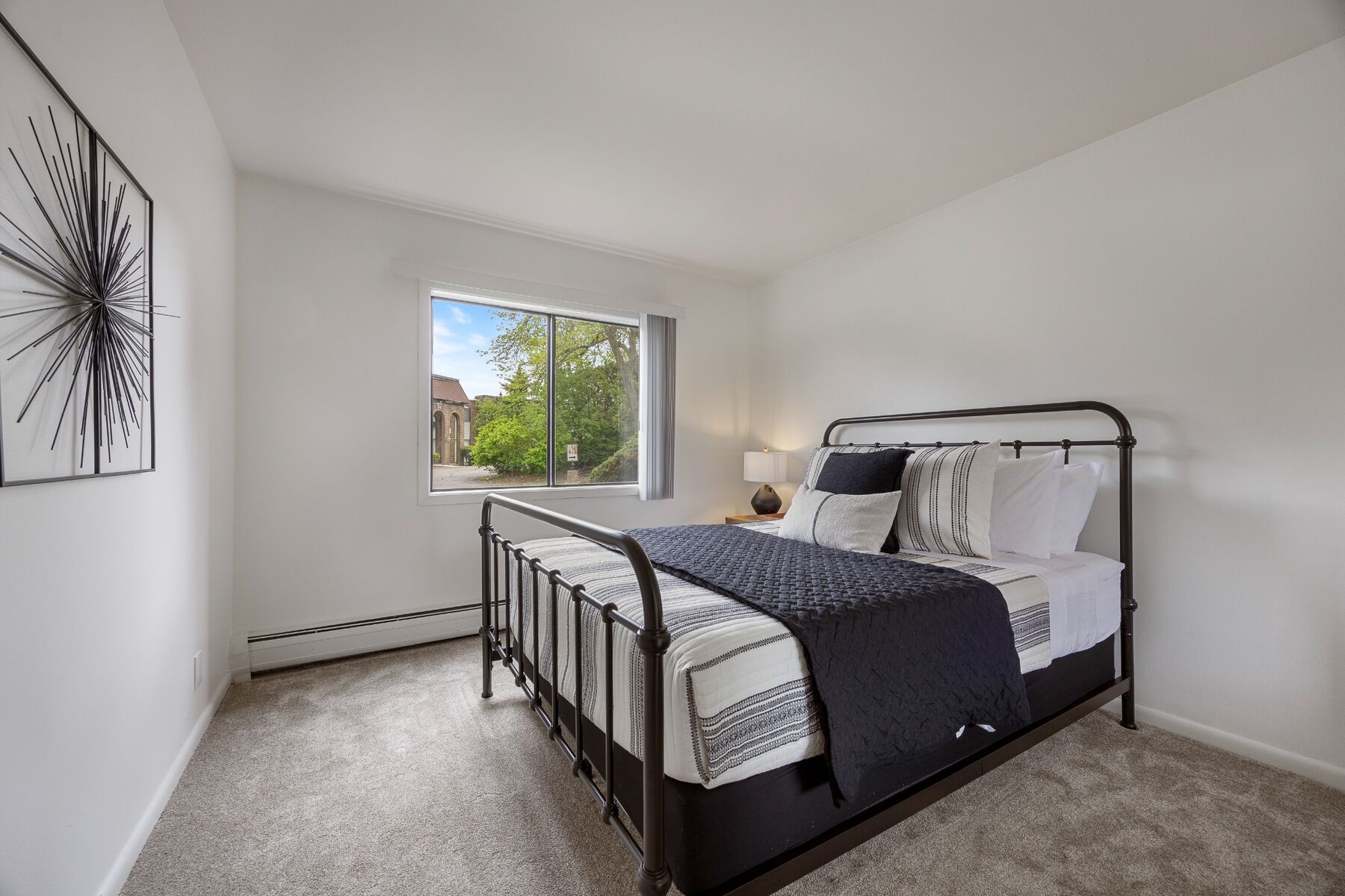 Second queen bedroom with window and metal bed frame
