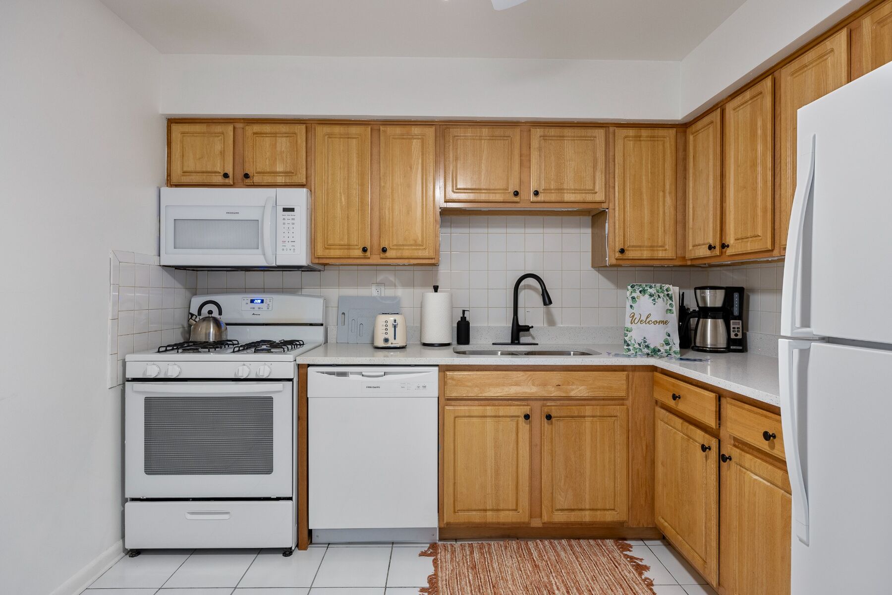 Fully equipped kitchen with gas range, dishwasher, microwave, and refrigerator