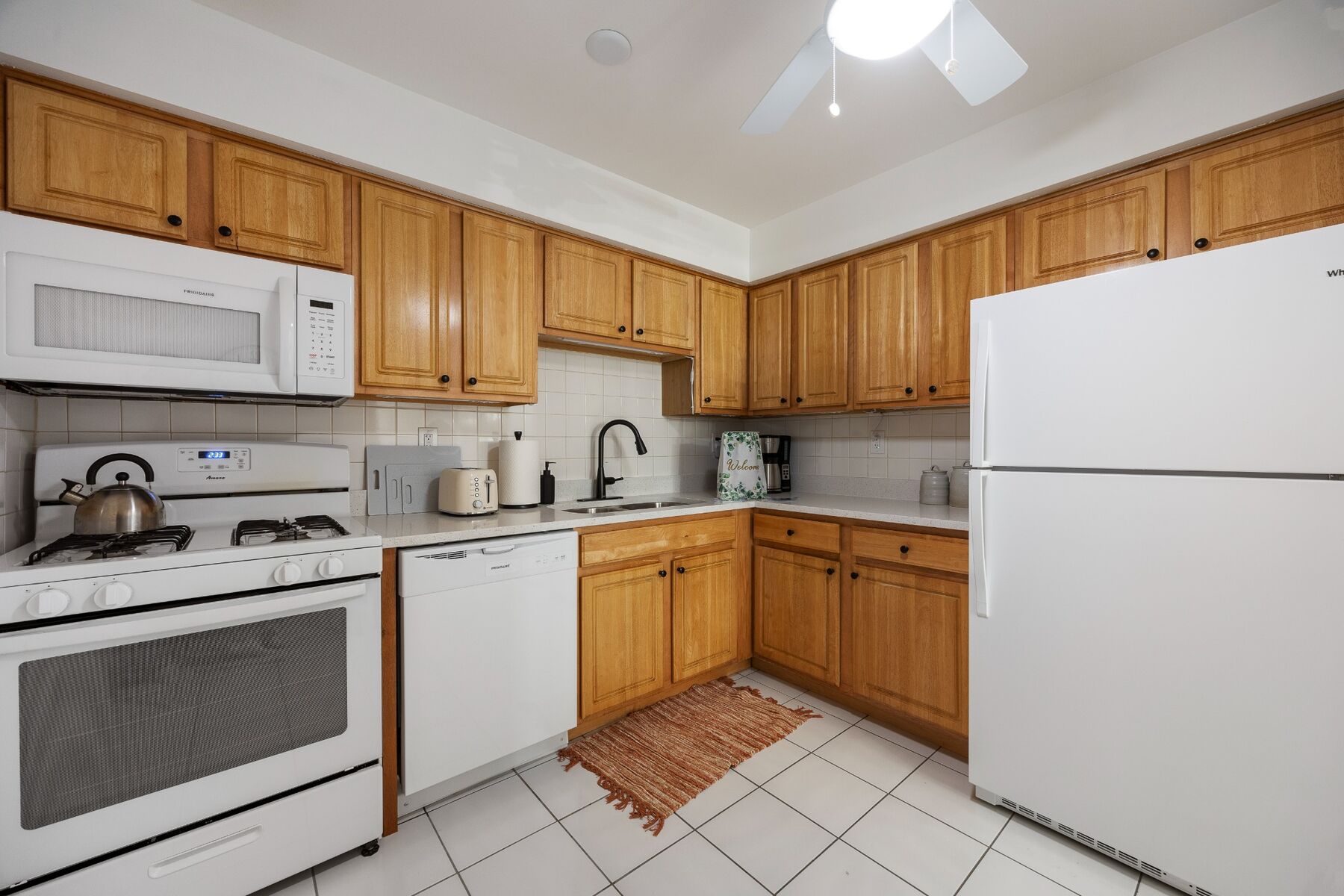 First-floor condo kitchen with wood cabinets and full-size appliances