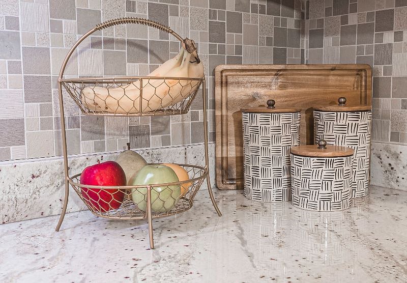 Kitchen counter storage with fruit basket and serving supplies