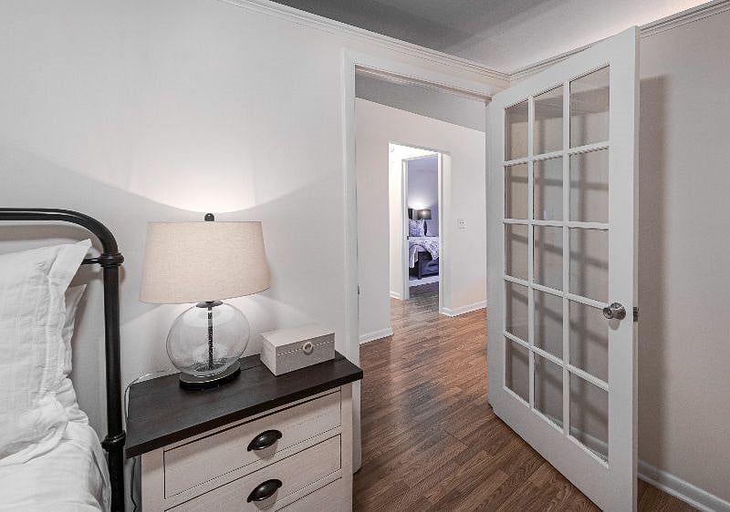 Second bedroom entrance with glass-panel door and wood flooring